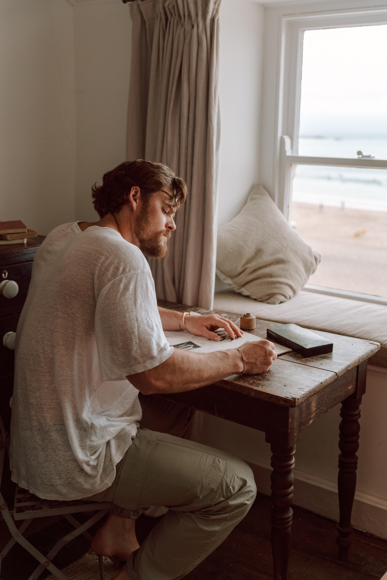 Ryan Libbey writing at a desk by the window